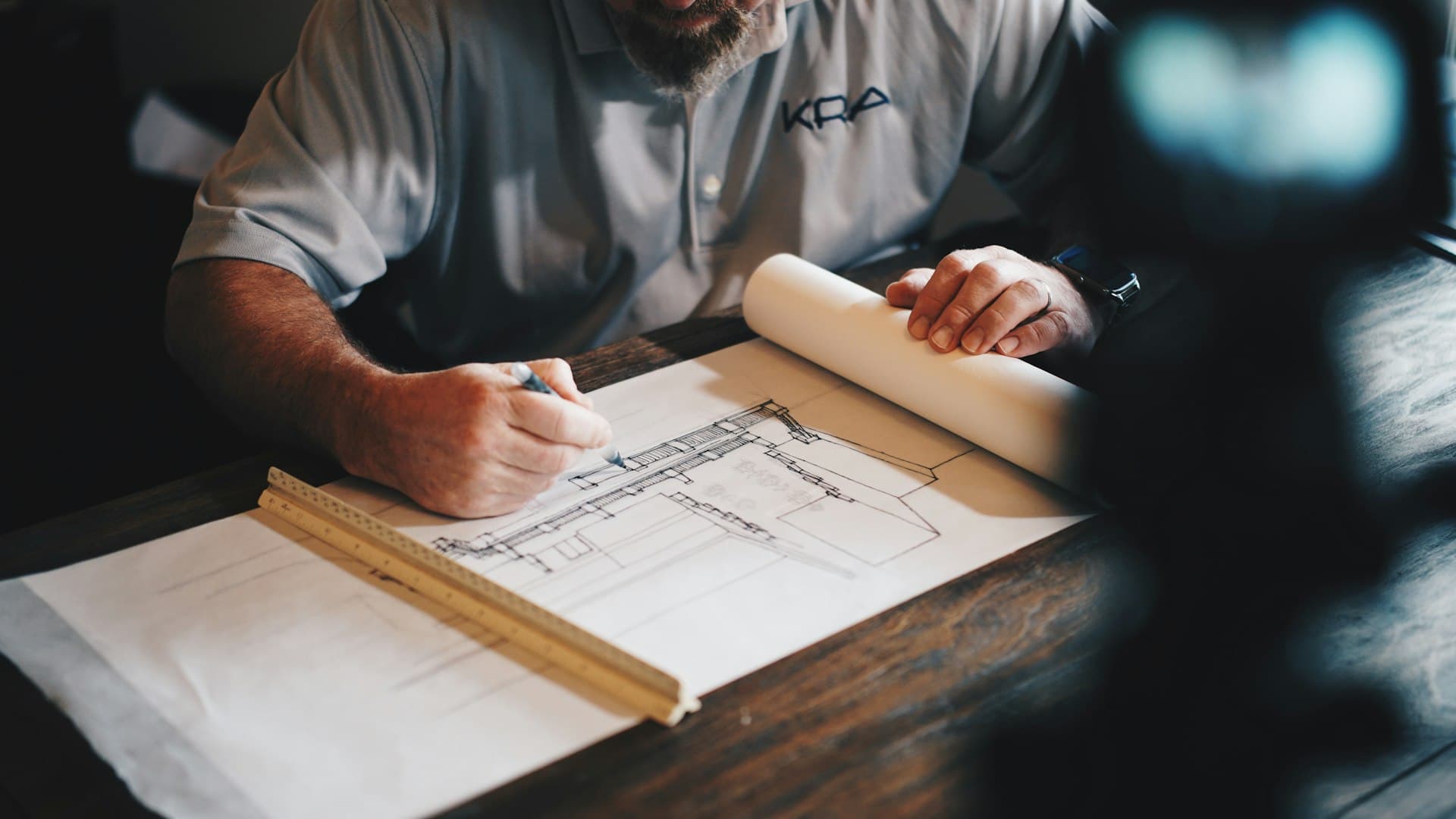 A craftsman studying woodworking blueprints and plans at a workbench